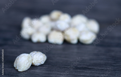 Candlenut or aleurites moluccana on wood background.