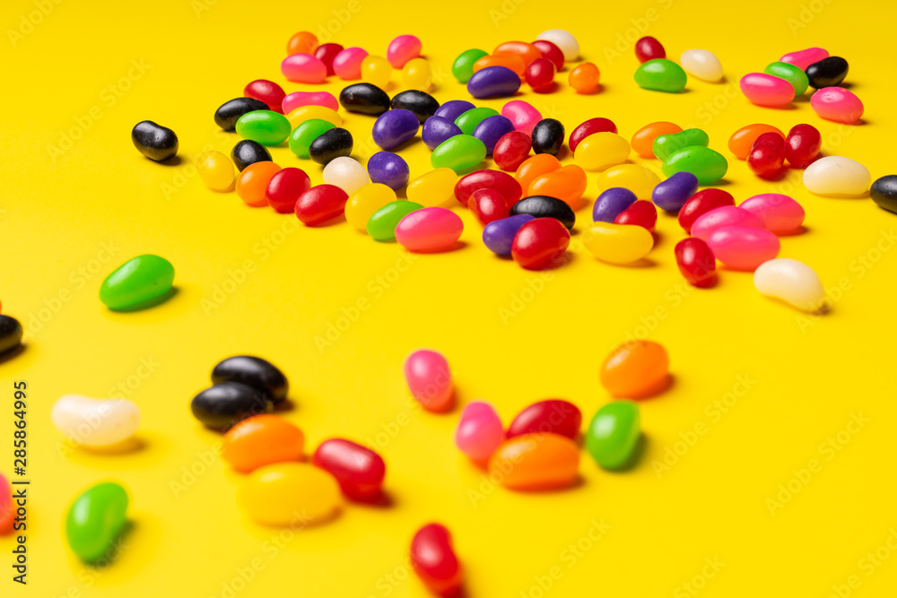 colourful jelly beans candies yellow background Top view colourful jelly beans candies yellow background Top view