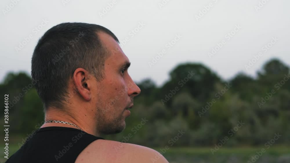 Close-Up Religious Man Attentively Repeats Mantra Sitting On Lake Shore Close-Up Religious Man Attentively Repeats Mantra Sitting On Lake Shore