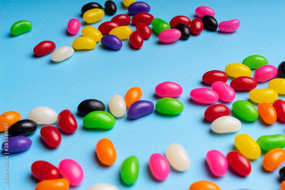colourful jelly beans candies blue background Top view
