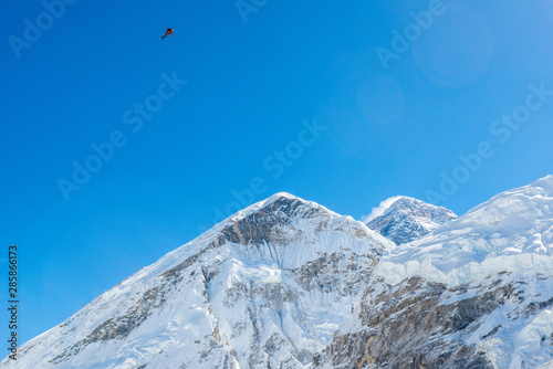 Scenic flight or rescue helicopter flying over Mt.Everest (8,848 m) the highest mountains peak in the world in Sagarmatha national park, Nepal.