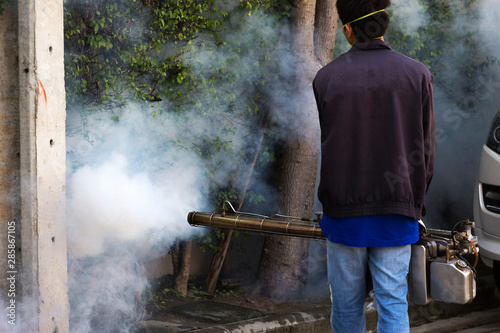 man using smoke machine for Desinsection and pest control photo