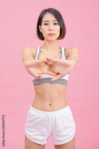 sport woman standing warm-up and stretch body before doing exercise on pink backgrounds, fitness concept, sport concept © I Believe I Can Fly