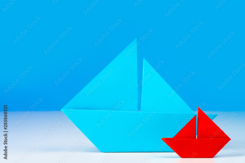 Emoji. Origami. Two paper boats. Boats of different sizes. From small grows large. Small and large business. Franchise. Subsidiary company. Emoji. Origami. Two paper boats. Boats of different sizes. From small grows large. Small and large business. Franchise. Subsidiary company.