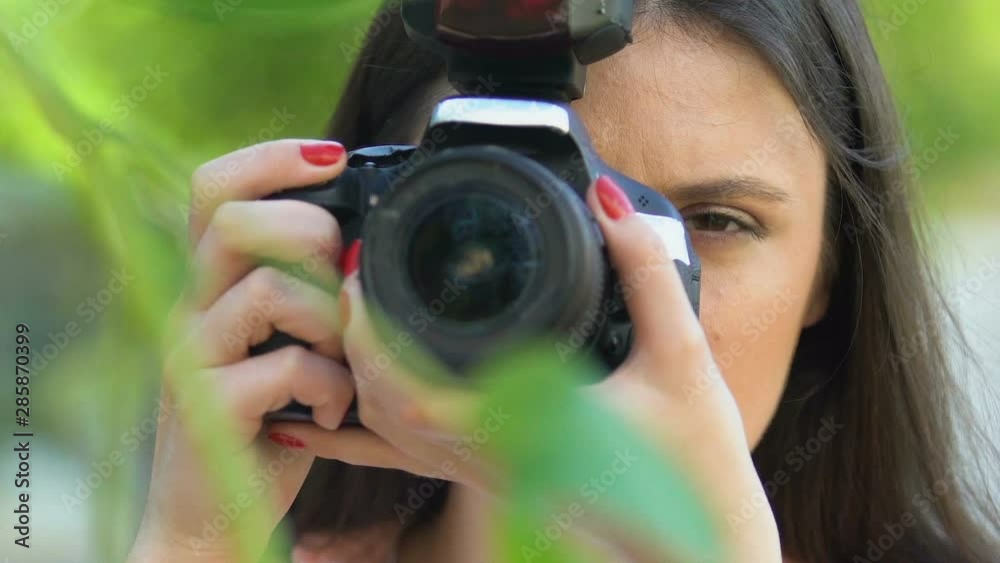 Female detective taking photo by camera hiding park, journalist spying celebrity Female detective taking photo by camera hiding park, journalist spying celebrity