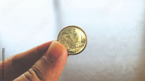 Close the Holding Australian Dollars Coin on Hand and Finger photo