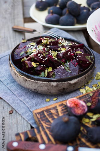 Sweet beetroot salad with black mission figs. Cooked with olive oil, vinegar, pumpkin and sesame seeds , herbs in bowl. Close up. photo