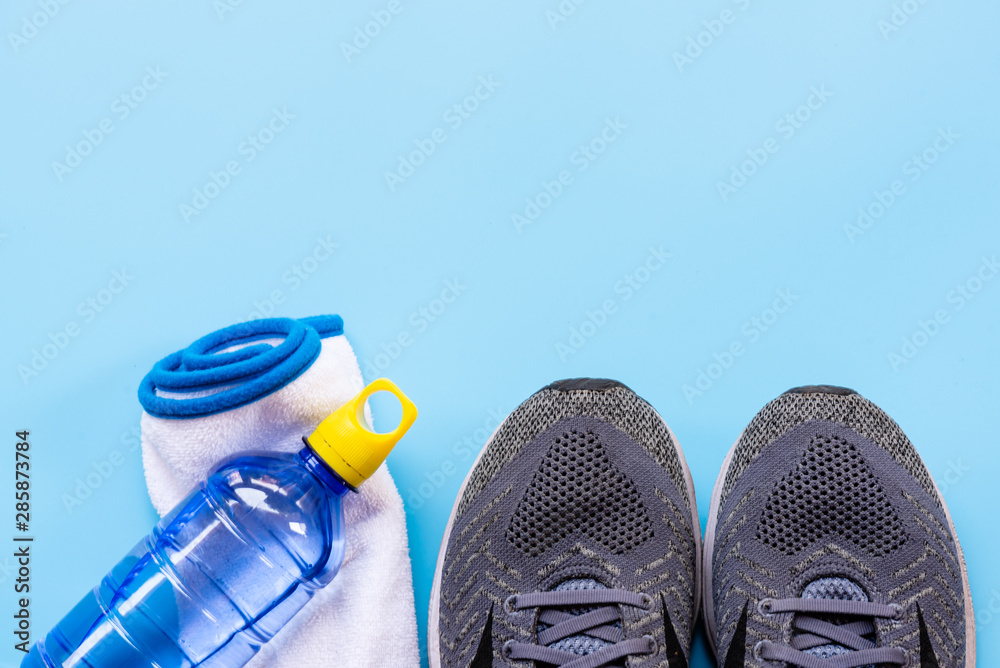 Running tools on blue  shoes, mobile phone, drinking water  bottle and blue tooth ear plug equipment for running healthy sport   sport accessories and copy space. Stock Photo | Adobe Stock