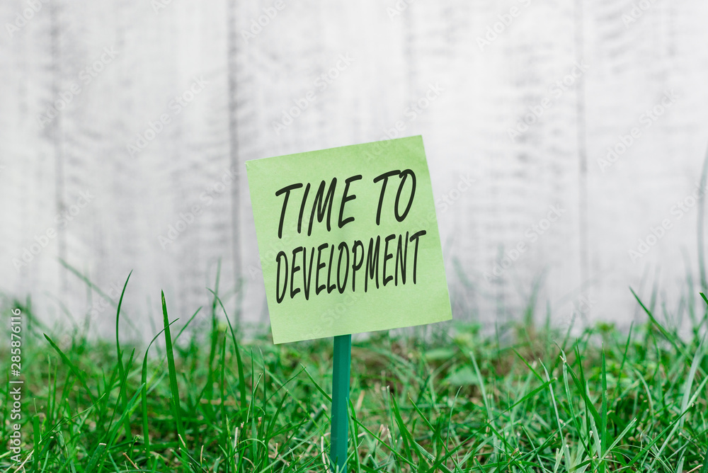 Word writing text Time To Development. Business photo showcasing a length of time during which a company grows or develop Plain empty paper attached to a stick and placed in the green grassy land