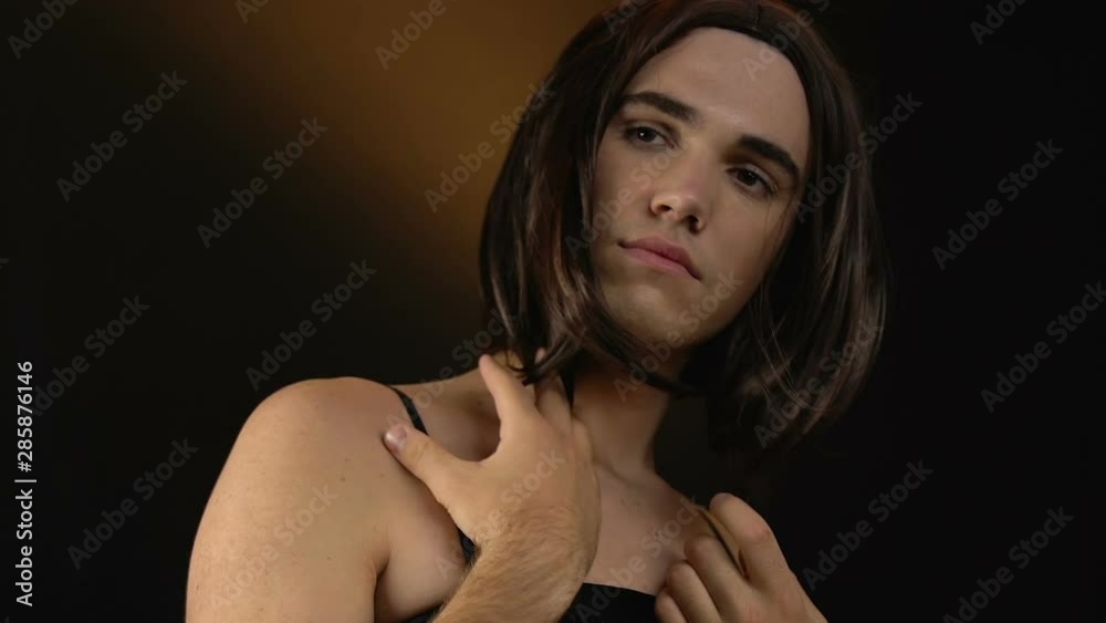 Transvestite in female wig and black dress admiring appearance, cross-dressing Transvestite in female wig and black dress admiring appearance, cross-dressing