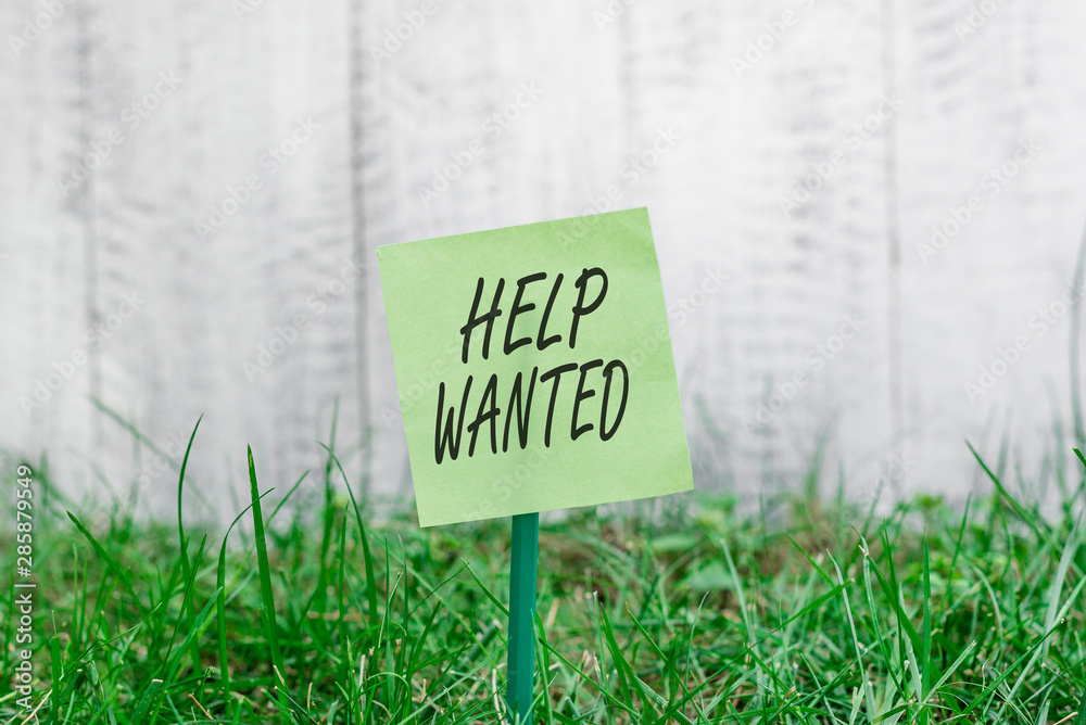 Word writing text Help Wanted. Business photo showcasing An ad in the paper an employer places to find a new employee Plain empty paper attached to a stick and placed in the green grassy land