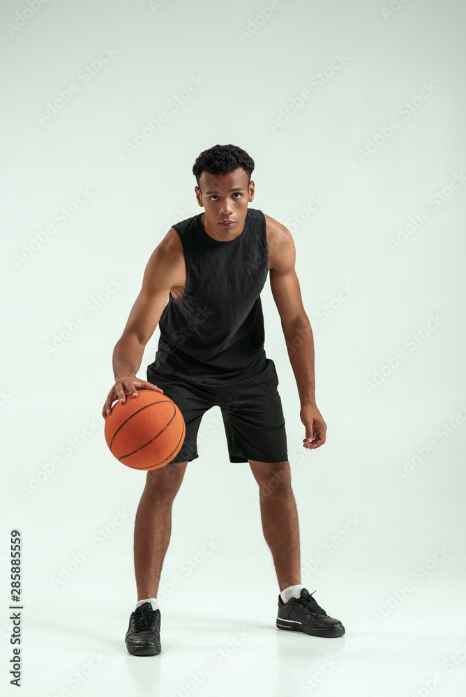 Great game. Full length of young african man in sports clothing playing basketball in studio against grey background Great game. Full length of young african man in sports clothing playing basketball in studio against grey background