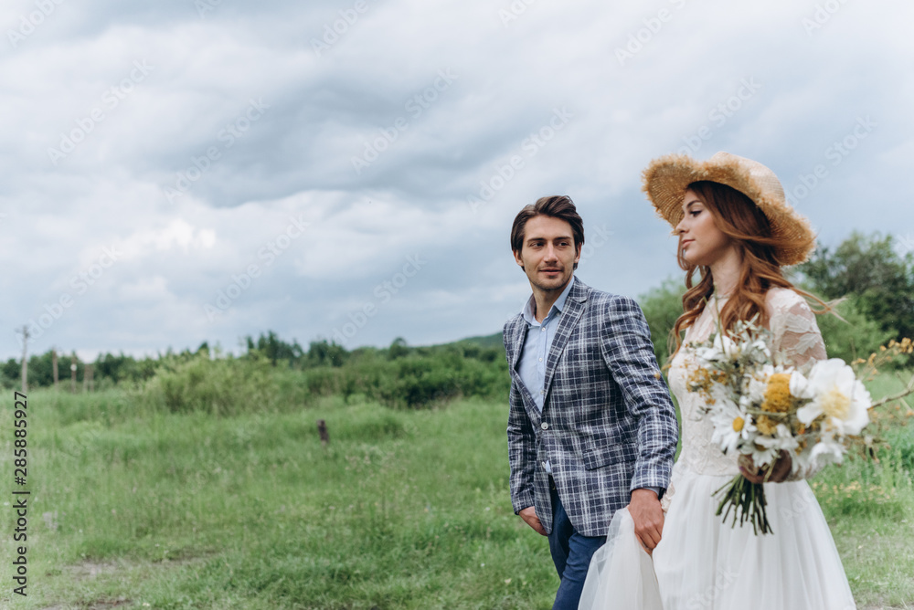 A young couple of brides have a fun and walking in the field outdoor A young couple of brides have a fun and walking in the field outdoor