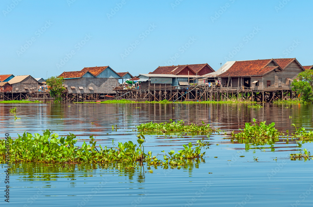 The colorful stilt houses in the floating village of Kompong Khleang by the Tonle Sap lake, Siem Reap, Cambodia. The colorful stilt houses in the floating village of Kompong Khleang by the Tonle Sap lake, Siem Reap, Cambodia.