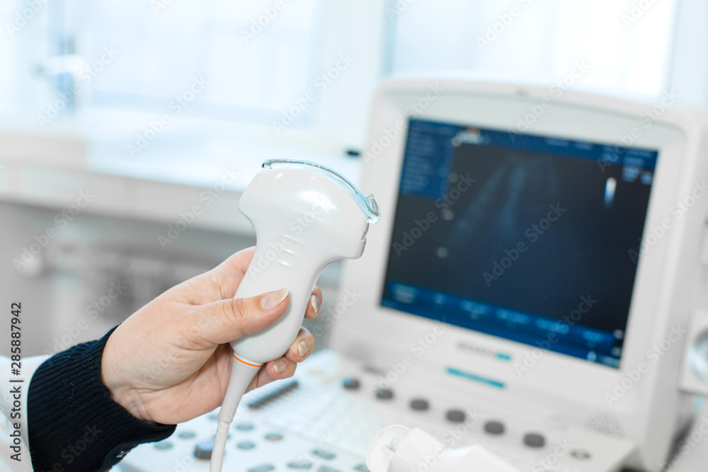 The doctor conducts an ultrasound of the stomach of a young girl