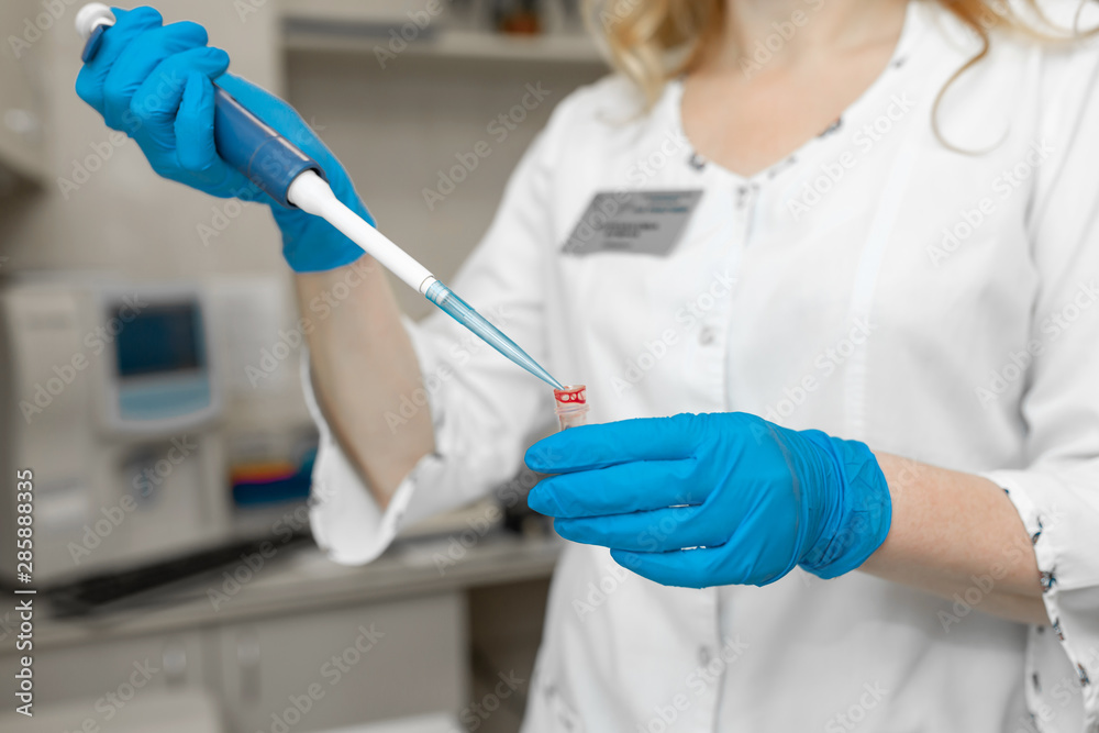 Woman lab technician take blood sample from test tube Woman lab technician take blood sample from test tube