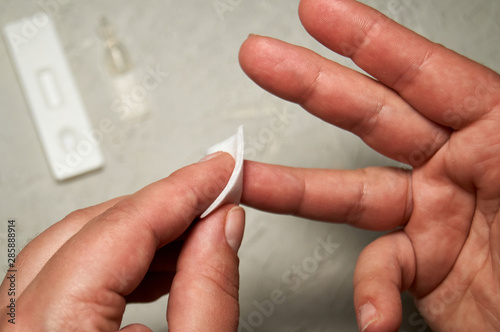 Close up of woman hands  cleaning the finger with an alcohol pad for express HIV test