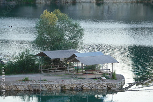gazebos on stone Bank of the quarry, green water and forest around. a place of rest for citizens. rocky shores of the lake, the production of stones.