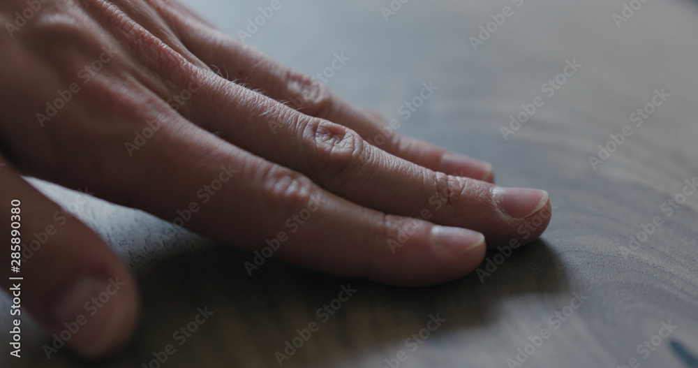 Fototapeta premium closeup man hand checking untrated black walnut solid board