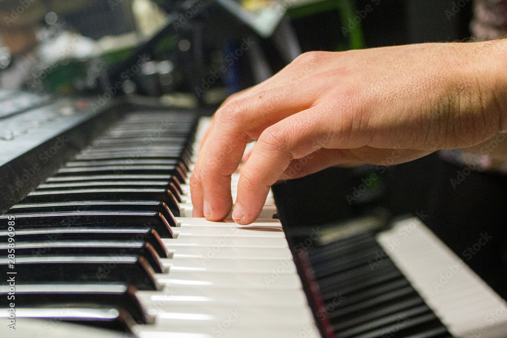 Le mani di un giovane ragazzo suonano una tastiera in una sala prove