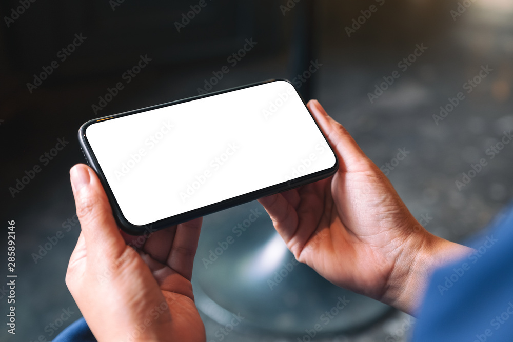 Mockup image of hands holding black mobile phone with blank desktop screen Mockup image of hands holding black mobile phone with blank desktop screen
