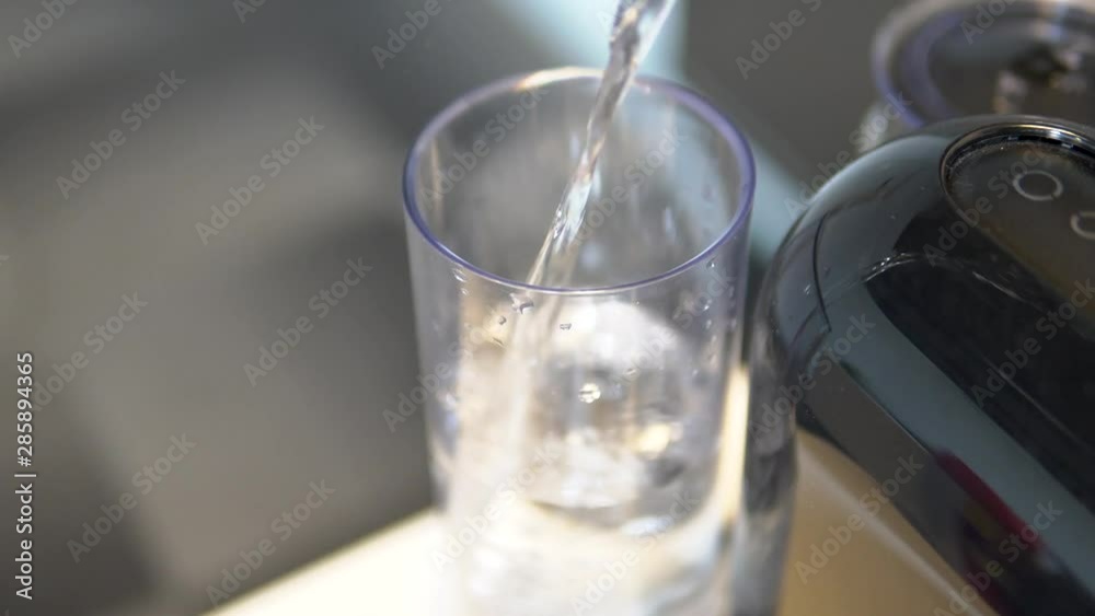 Static close-up shot of pouring water into a coffee machine water tank