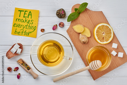 Cup of hot tea and healthy natural ingredients. Tea cup with honey, ginger, lemon and mint on wooden background.