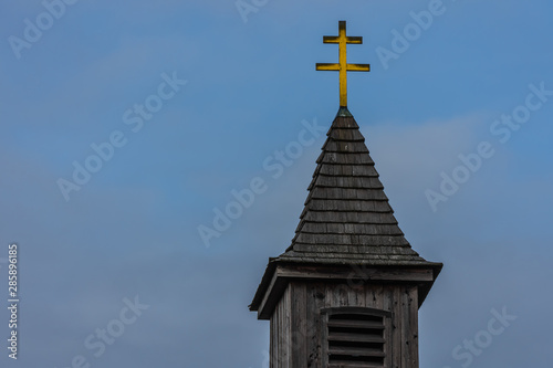 kirchturm mit kreuz und blauer himmel