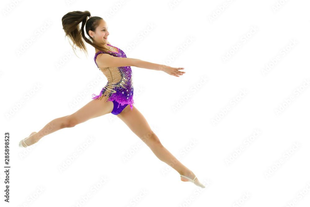 The girl gymnast performs a jump. The girl gymnast performs a jump.