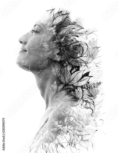 Double exposure. Paintography. Close up profile portrait of an attractive woman with strong ethnic features combined with unusual hand made drawings with floral and plant motifs, black and white
