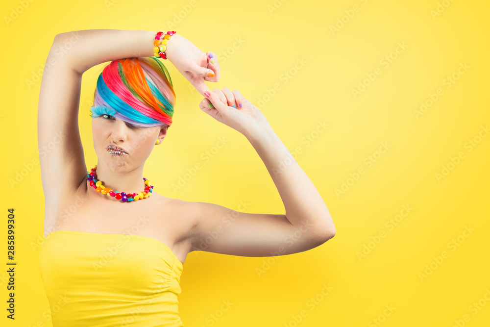 Girl with rainbow colorful fashion makeup on yellow background. Girl with rainbow colorful fashion makeup on yellow background.
