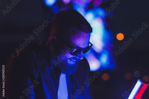 Neon portrait of smiling man model with beard in sunglasses and leather jacket © jozzeppe777