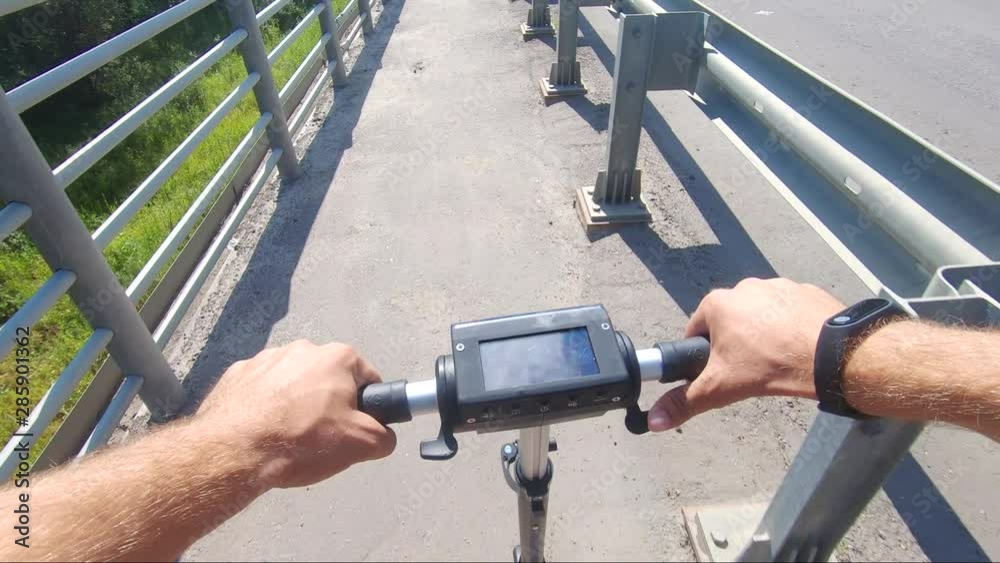 Close-up of man hands and steering wheel of electric scooter. Man holding the handlebar of an electric scooter. Concept of ecological transport.