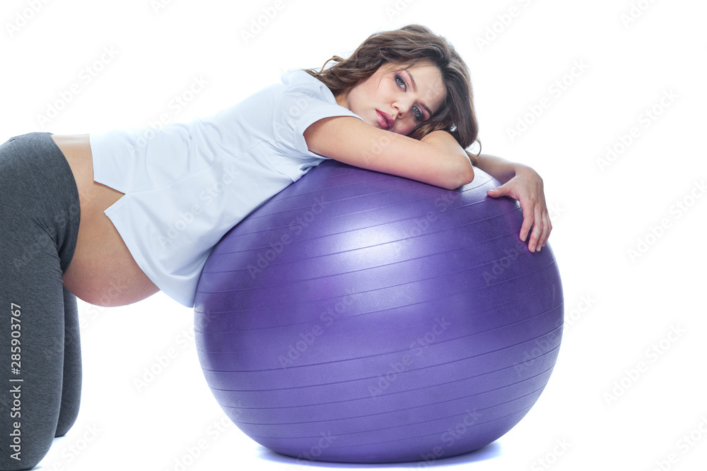 Portrait of a beautiful young pregnant woman exercises with fitball. Working out and fitness, pregnancy concept. Isolated white background. Portrait of a beautiful young pregnant woman exercises with fitball. Working out and fitness, pregnancy concept. Isolated white background.