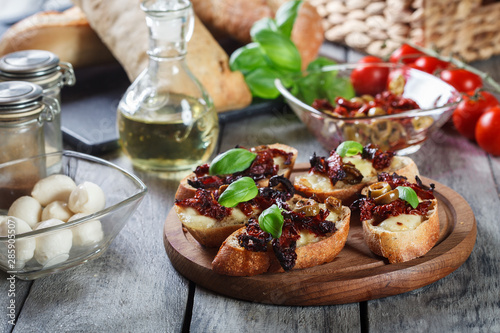 Appetizer bruschetta with sun-dried tomatoes  olives and mozarella.