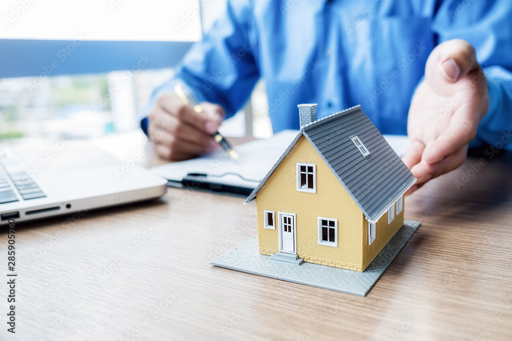 Car and House model with agent and customer discussing for contract to buy, get insurance or loan real estate or property background Car and House model with agent and customer discussing for contract to buy, get insurance or loan real estate or property background