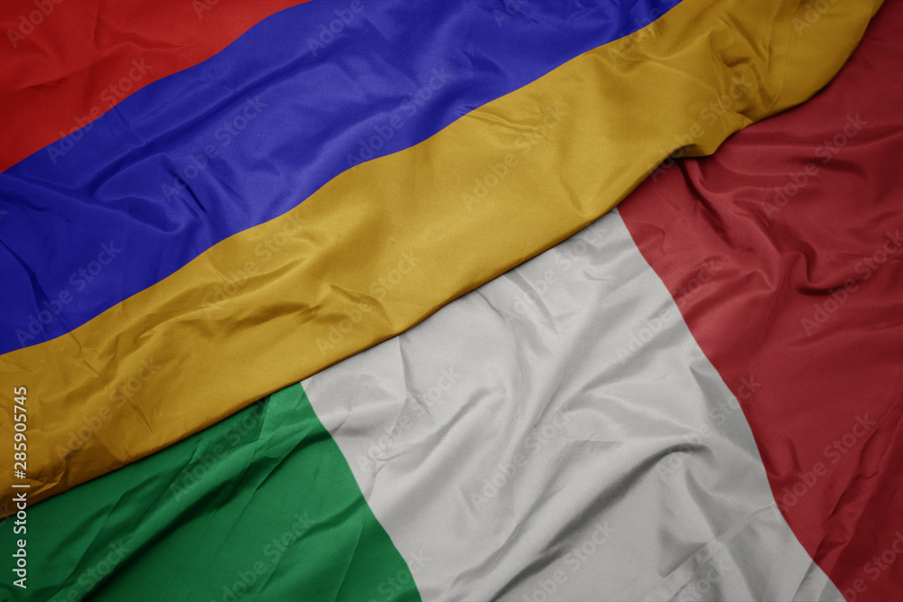 waving colorful flag of italy and national flag of armenia.