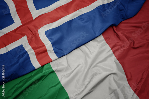 waving colorful flag of italy and national flag of iceland.