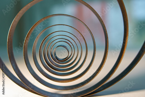 Industrial concept. Old metal spiral on a window background