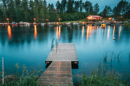 Fototapeta Naklejka Na Ścianę i Meble -  Sweden. Beautiful Wooden Pier Near Lake In Summer Evening Night. Lake Or River Landscape