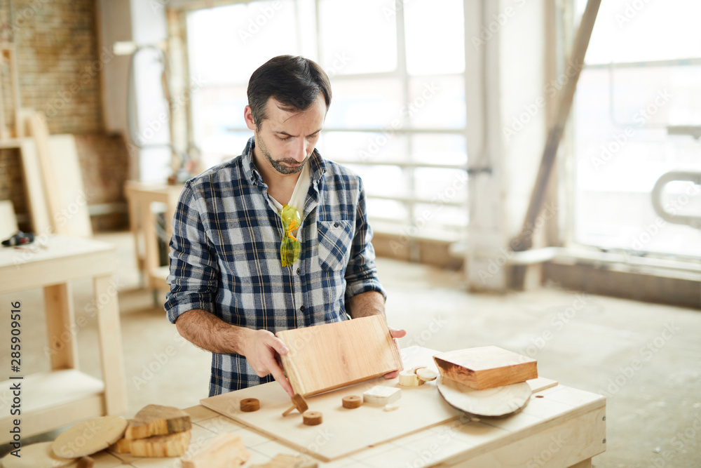 Portrait of mature carpenter working with wood in workshop, copy space Portrait of mature carpenter working with wood in workshop, copy space