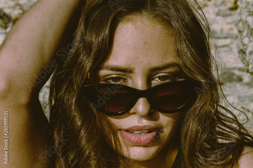 Portrait of young hipster woman with sunglasses enjoying summer. Autumn is approaching with good temperatures. autumnal beach.