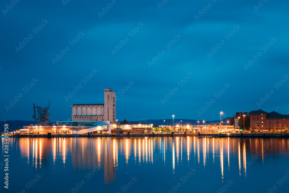 Oslo, Norway. Night View Embankment And Sea Port Terminal In City Center In Oslo, Norway. Summer Evening. Lights Reflected In Sea Water