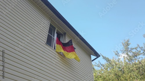 Young people waving a flag in a window at home photo