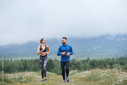 Happy couple doing cardio warm up outdoor on gloomy day