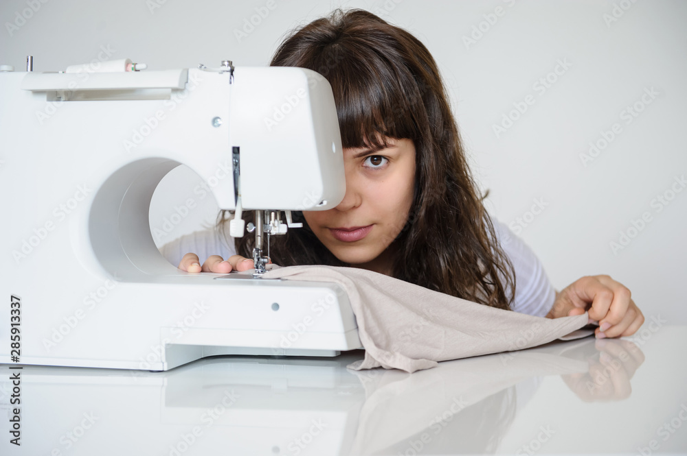 close up photo of a sexy brunette working at the sewing machine