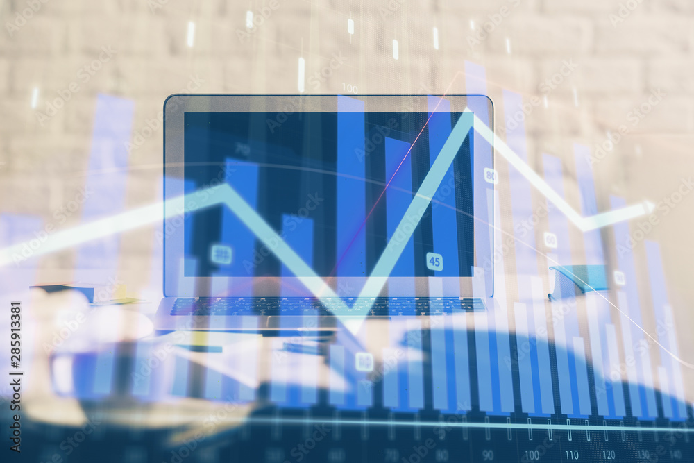 Stock market graph on background with desk and personal computer. Double exposure. Concept of financial analysis.