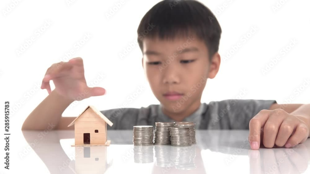 4k Young Asian boy put a mini house on a coin tower 4k Young Asian boy put a mini house on a coin tower