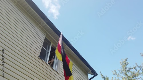 Young people waving a flag in a window at home photo
