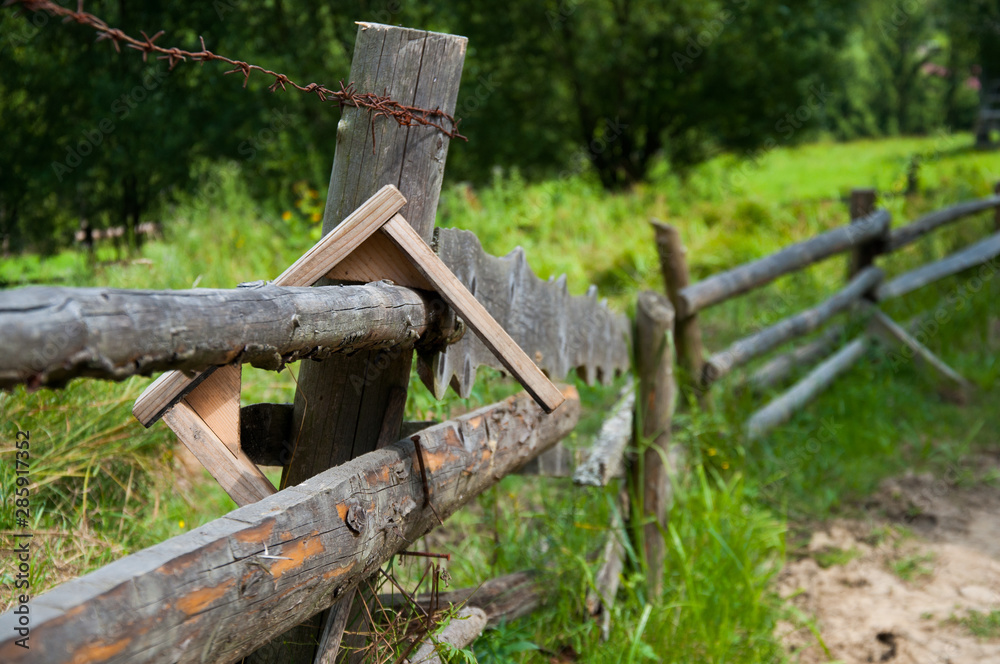 Fototapeta premium Old wooden fence in the mountains. Forest and tall trees. Mountains and hills. Summer